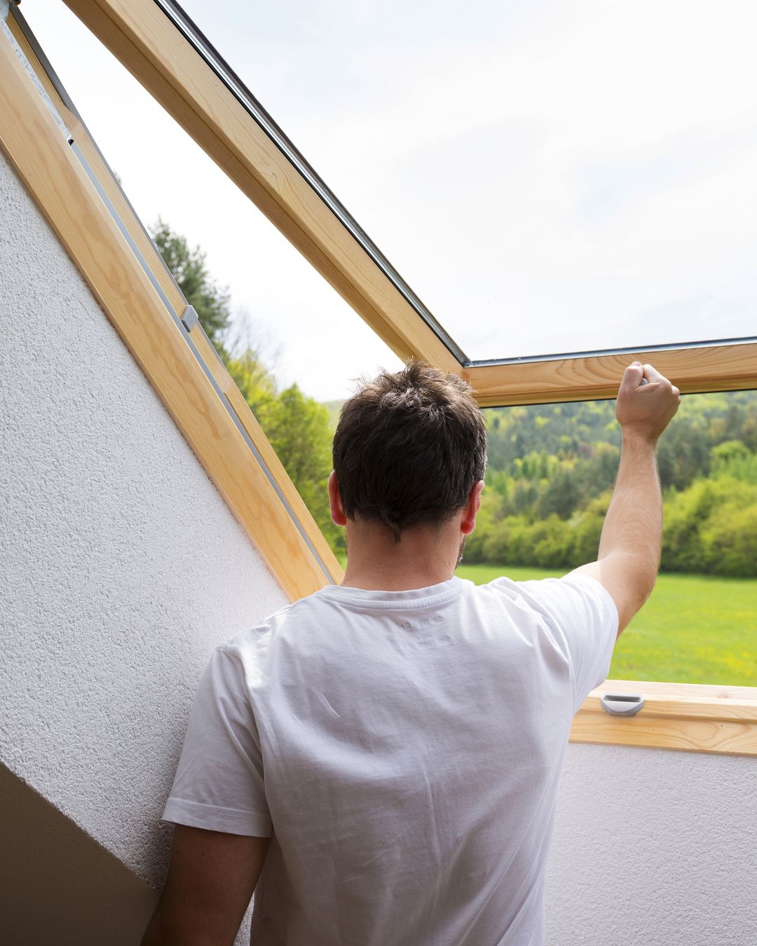 Mensch öffnet Dachfenster